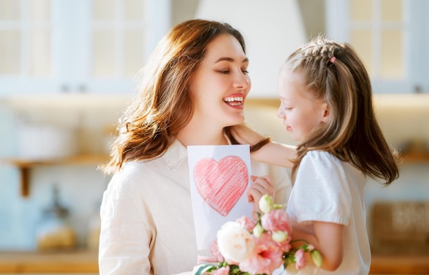 Filha dando buquê de flores para a mãe