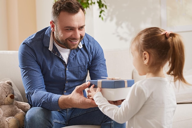 Filha dando presente para o pai em casa