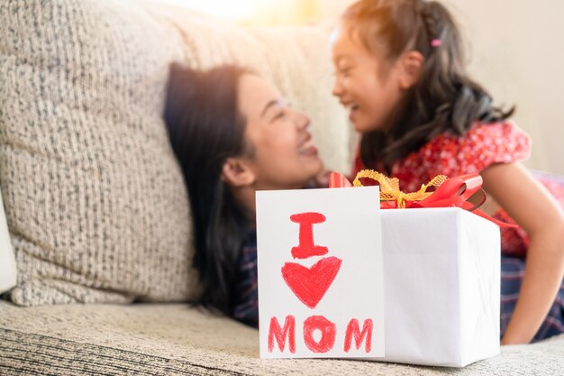 Filha dar cartão de dia das mães para a mãe