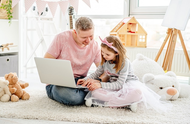 Filha de ensino do pai para usar o laptop