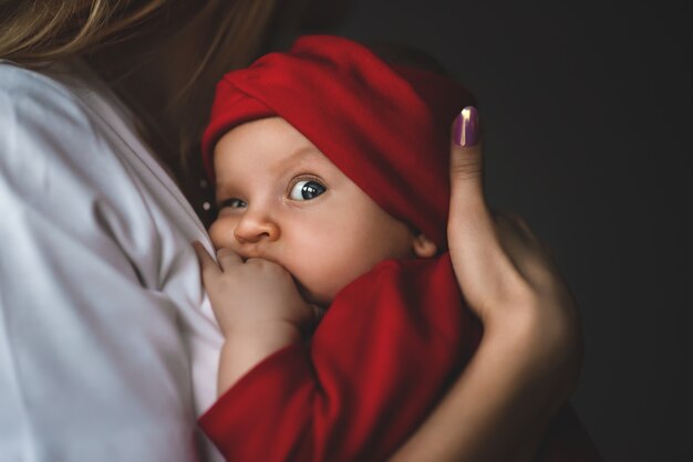 Filha de mãe amorosa bebê recém-nascido afago sobre o ombro.