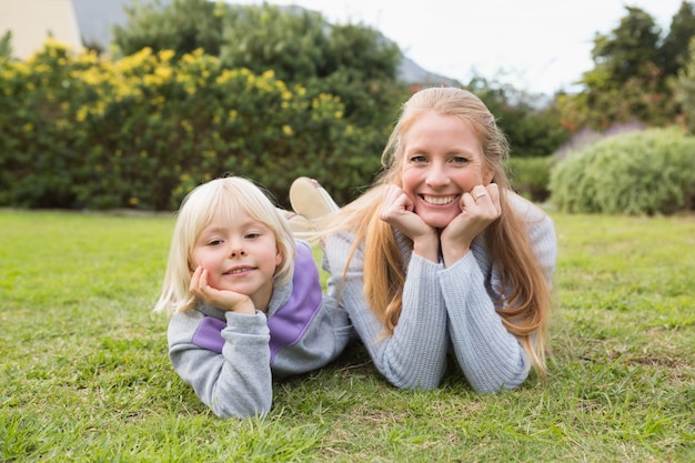 Filha e mãe bonitinha sorrindo na câmera