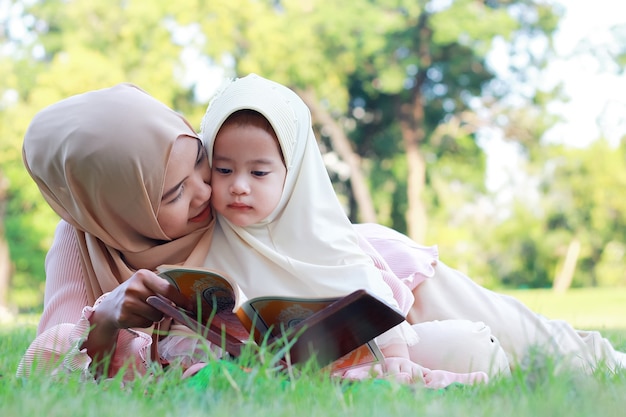 Filha e mãe muçulmana gostam de relaxar no parque.