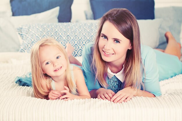 Filha e Mãe Sorrindo. Mulher feliz e menina criança. Filha e mãe em casa