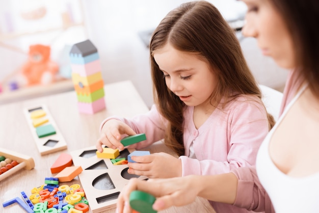 Filha estão brincando com figuras geométricas.