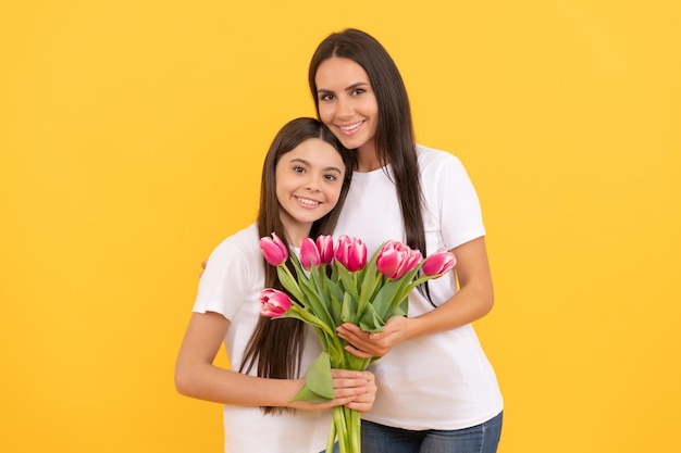 Filha feliz, filha e mãe seguram buquê de flores de tulipa da primavera para o feriado de 8 de março, dia das mulheres.