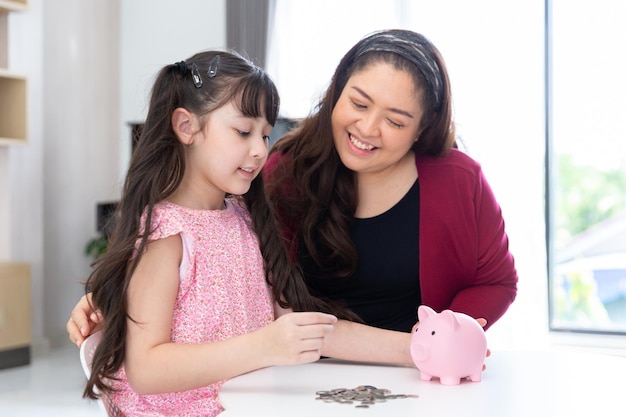 Filha feliz sorridente coleta moedas para economizar dinheiro para educação e economia no cofrinho