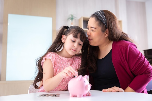 Filha feliz sorridente coleta moedas para economizar dinheiro para educação e economia no cofrinho