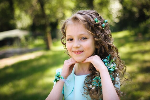 Filha feliz sorrindo para a câmera no parque de verão