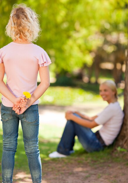 Filha oferecendo uma flor a sua mãe