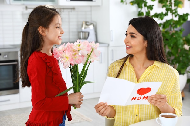 Filha parabenizando sua mãe na cozinha Feliz Dia das Mães