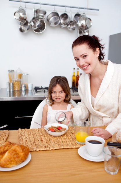 Filha tomando café da manhã com sua mãe