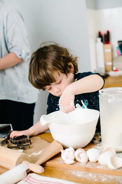 Filho ajuda mãe a cozinhar na cozinha