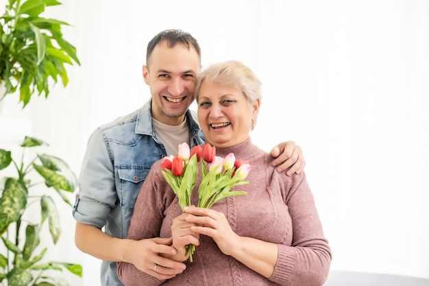 Filho dando mãe flores tulipas.