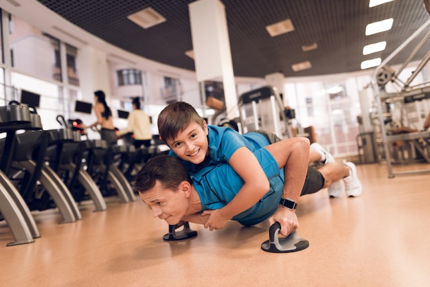 Filho está deitado na parte de trás de seu pai enquanto está sendo espremido