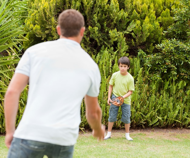 Filho jogando futebol com seu pai