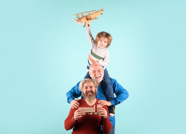 Filho menino com pai e avô com um avião de brinquedo joga no fundo isolado