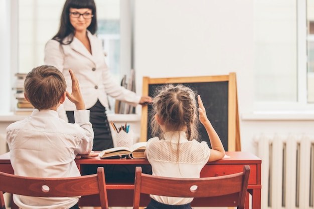 Filhos de meninos e meninas com o professor na escola