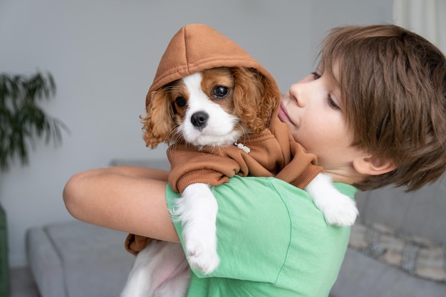 Filhote de cachorro bonito vestindo um capuz marrom Roupas de outono e inverno para animais de estimação Cavalier King Charles Spaniel Blenheim