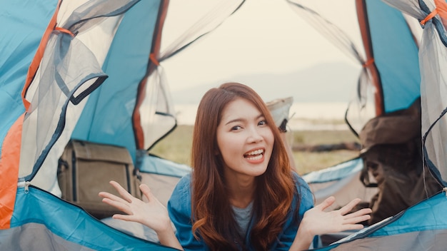 Filmagem de gravação de uma garota influente de adolescente da Ásia apresenta e acampa para seu seguidor desfrutar de momentos felizes no acampamento