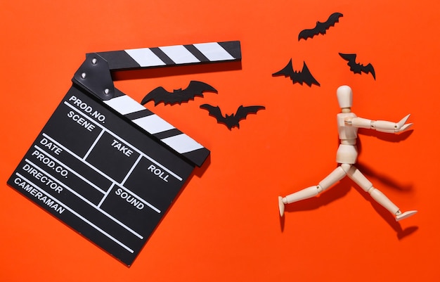 Filme de terror, tema de halloween. Claquete de cinema, fantoche e morcegos decorativos voadores em laranja brilhante