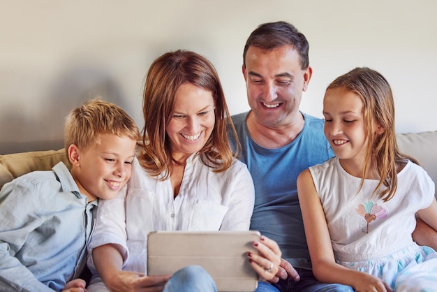 Filme feliz e família com tablet no sofá para streaming online rede digital e assinatura pai mãe e filhos com tecnologia em casa para o desenvolvimento de ligação e filme na internet