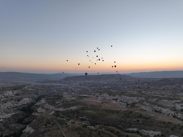 Filmische Drohnenansicht eines farbenfrohen Heißluftballons, der über Kappadokien fliegt