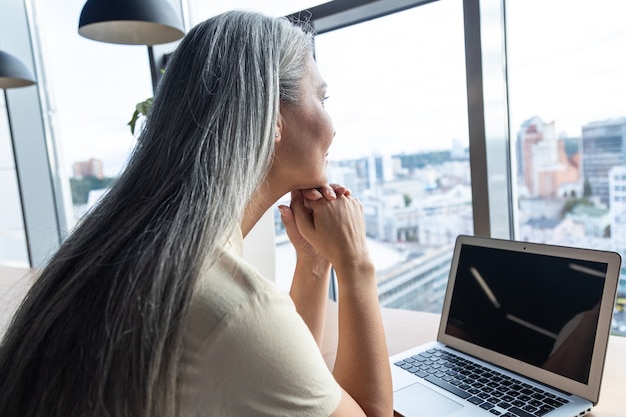 Filmisches Bild einer älteren Geschäftsfrau. Porträt einer Mitarbeiterin in ihrem Büro