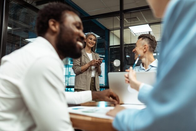 Filmisches Bild von Mitarbeitern eines multiethnischen Geschäftsteams, die in einem modernen Büro zusammenarbeiten