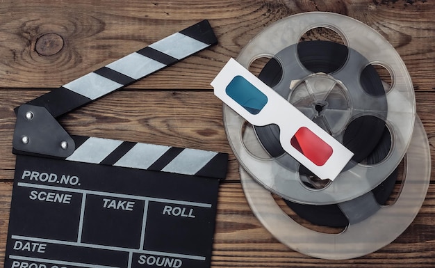 Filmklappe und Filmrolle, 3D-Brille auf Holzhintergrund. Kinoindustrie, Unterhaltung. Ansicht von oben