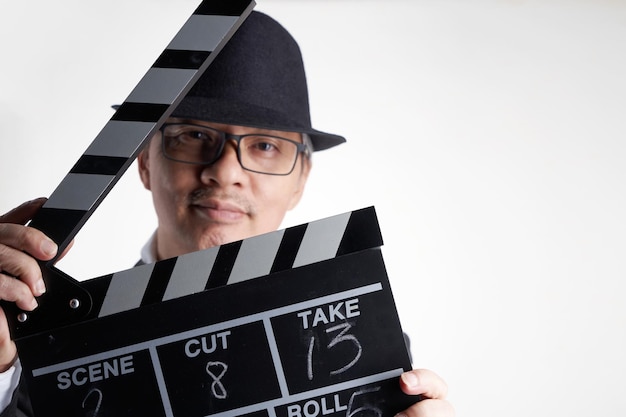 Filmregisseur mit Filmklappe vor weißem Hintergrund