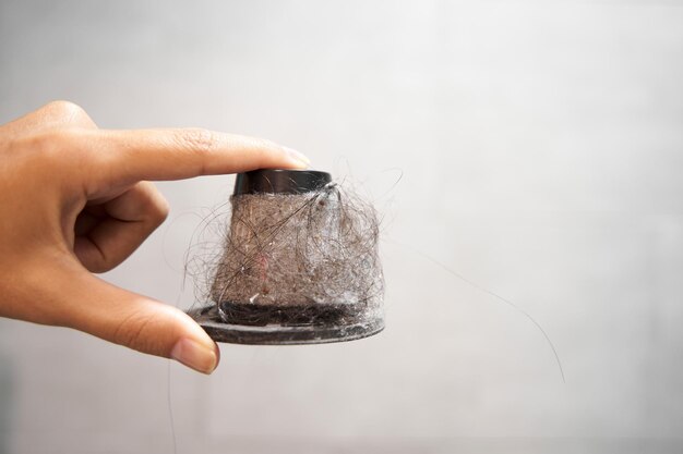 Foto filtro de papel sujo de um aspirador de mão um homem segura um filtro de cone com poeira e cabelo em um lixo