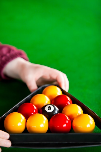 Fim acima de um jogador de snooker colocando bolas com triângulo