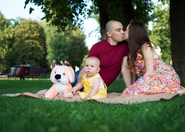 Fim de semana da família Mãe e filho em um parque de verão estão sentados em um gramado verde