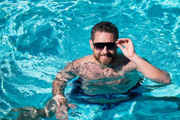 Fim de semana de verão homem bonito na piscina piscina spa resort férias de verão