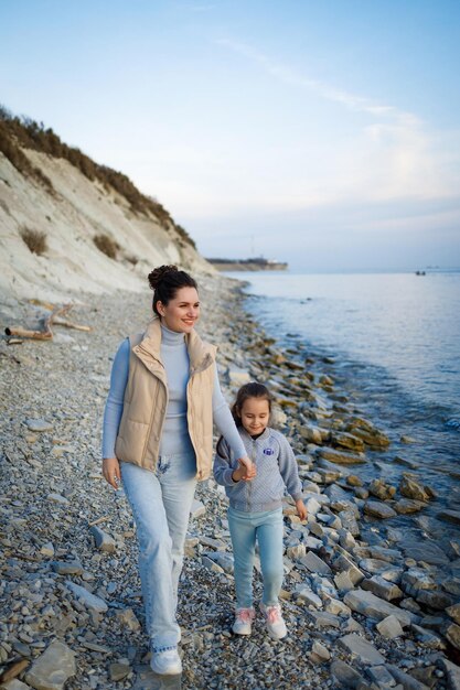 Fin de semana familiar junto al mar feliz madre e hija se divierten en un paseo puesta de sol en el mar