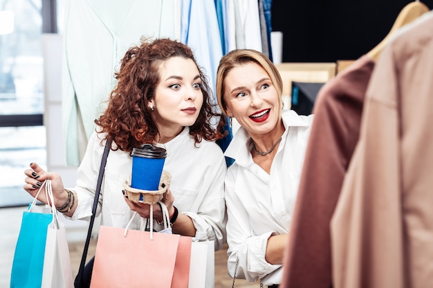 En el fin de semana. Hija rizada y madre rubia de compras juntas el fin de semana