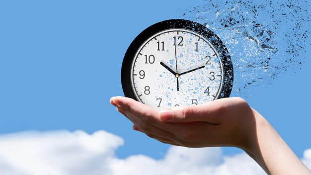 Fin del tiempo o concepto de vuelo del tiempo. Mano femenina sosteniendo un clásico reloj redondo cayendo en pedazos pequeños contra un cielo azul, vista frontal, espacio de copia