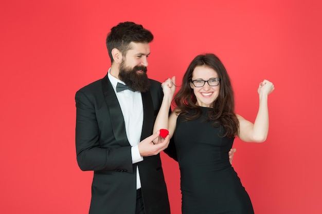 Finalmente celebración del día de san valentín feliz pareja sexy enamorada esmoquin hombre y dama en la celebración del compromiso hombre barbudo hacer mujer propuesta de matrimonio pareja formal anillo en caja fecha de amor sí