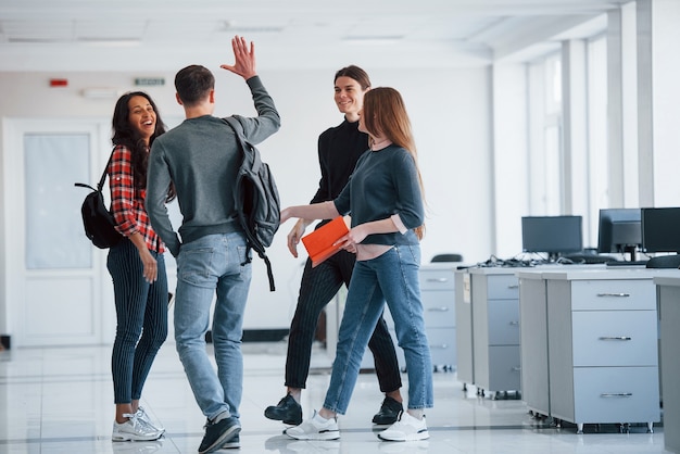 Finalmente nos conhecemos. Grupo de jovens andando no escritório na hora do intervalo.