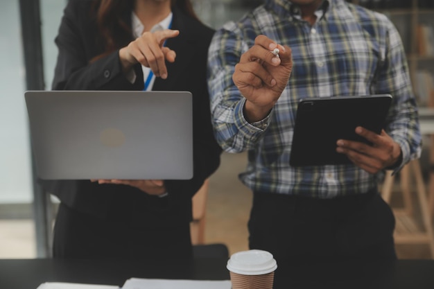 Finanzanalysten analysieren Geschäftsfinanzberichte zu einem digitalen Tablet, das ein Investitionsprojekt plant, während einer Diskussion auf einer Unternehmensbesprechung und zeigen die Ergebnisse ihrer erfolgreichen Teamarbeit