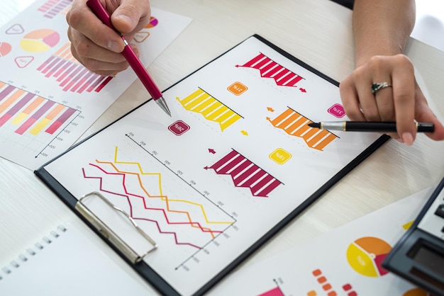 Finanzanalysten, die mit Grafiken und Diagrammen arbeiten. Menschliche Hände mit Stiften aus nächster Nähe