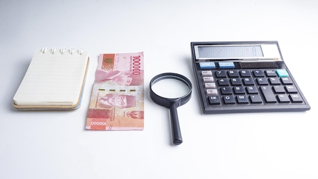 Finanzas ahorro economía y concepto de hogar Calculadora lupa portátil y billetes reales indonesios Dinero indonesio Economía de Indonesia