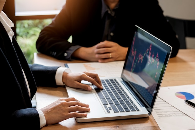 Finanzas gerente de comercio que muestra los informes de análisis de pantalla finanzas de los datos de divisas en el comercio de valores gráfico en el mercado de divisas de negocios