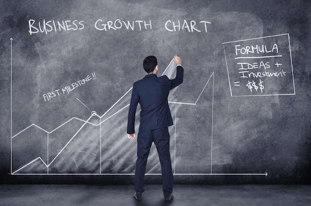 Finanzgeschäftsmann, der auf CGI-Grafikdiagramm schreibt, während er die Planung und Arbeit an Unternehmensbudget-Marketingstatistiken oder -daten auf dunklem Hintergrund analysiert Rückseite des Buchhalters mit Analyse des Karrierewachstums