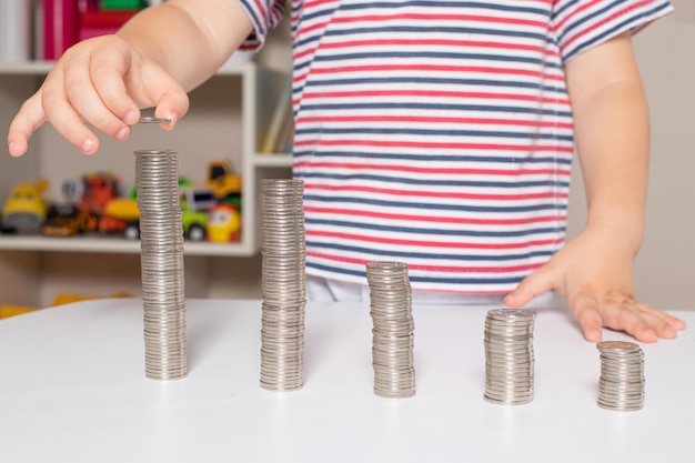 Finanzielle Bildung von Kindern und Münzen für Kinder, die lernen, Geld auszugeben