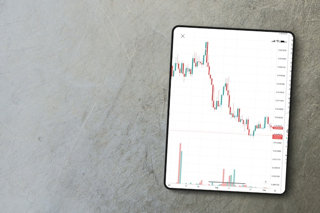 Finanzmarktdiagramm auf dem Tablet-Bildschirm auf Zementhintergrund. Ansicht von oben. Börse.