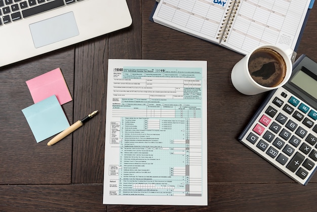 Finanzsteuerformular mit Taschenrechner, Laptop und Stift