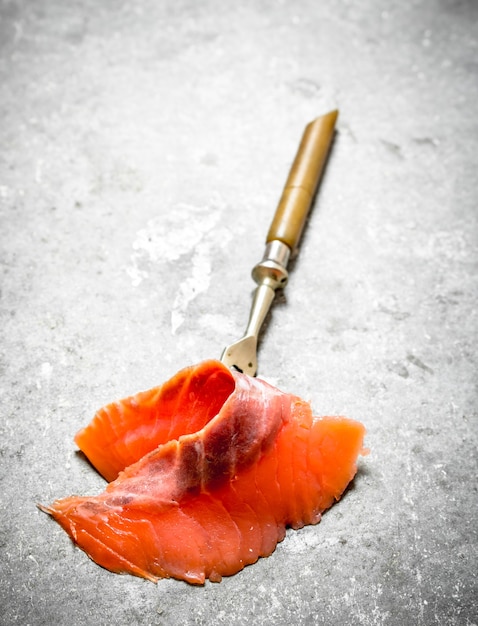 Finas lonchas de salmón ahumado con tenedor