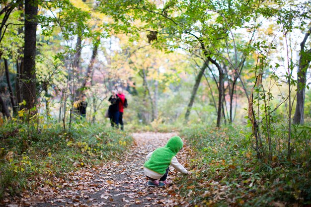 A fines del otoño, la espalda de un niño se pasea por el espacio verde